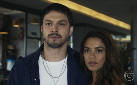 O ator Romulo Estrela contracena com Lucy Alves em cena da novela Travessia; ambos estão com expressões de descontentamento