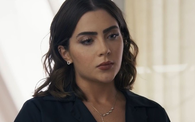 Jade Picon caracterizada como Chiara; ela tem o semblante sério e taciturno em cena de Travessia