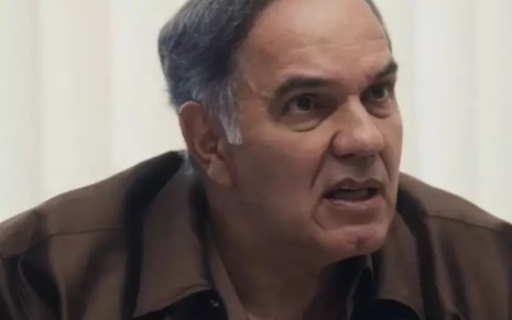 O ator Humberto Martins usa casaco e está em close em cena da novela Travessia como Guerra