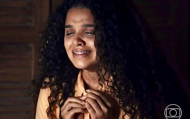 A atriz Danielle Olímpia desabotoa blusa e chora em cena da novela Travessia como Karina