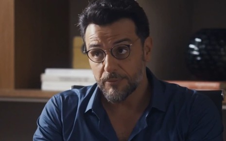 O ator Rodrigo Lombardi com expressão séria em cena de Travessia
