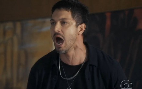 O ator Romulo estrela grita em gravação de cena da novela Travessia caracterizado como o hacker Oto