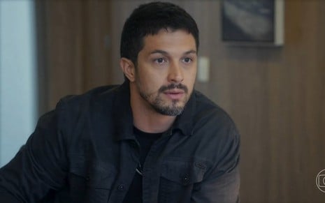 O ator Romulo Estrela olha para a frente com expressão de espanto em cena da novela Travessia na qual interpreta Oto
