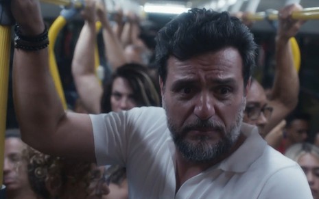 Moretti (Rodrigo Lombardi) com cara de choro dentro de um ônibus lotado em cena de Travessia