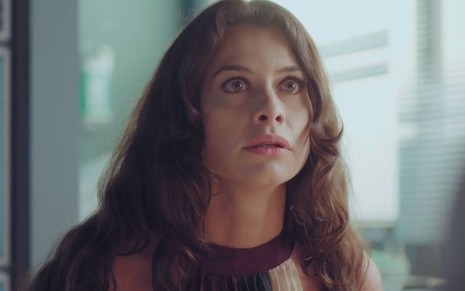 Bárbara (Alinne Moraes) está sentada em consultório em cena de Um Lugar ao Sol, novela das nove