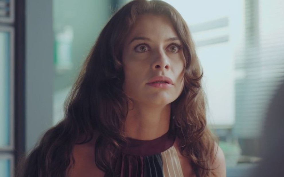 Alinne Moraes, caracterizada como Bárbara, expõe semblante chocado, com olhos arregalados e boca semiaberta, em cena de Um Lugar ao Sol