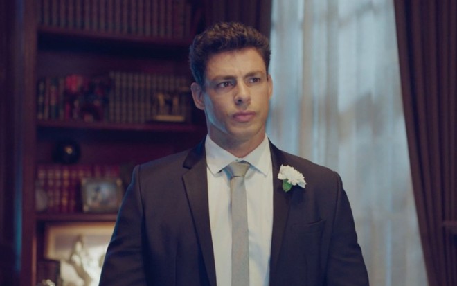 O ator Cauã Reymond caracterizado como o personagem Christian olhando sério, trajado de smoking, em cena da novela das nove da Globo Um Lugar ao Sol