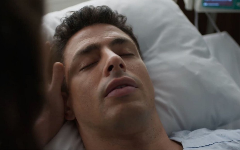Christian/Renato (Cauã Reymond) está deitado em leito de hospital cena de Um Lugar ao Sol