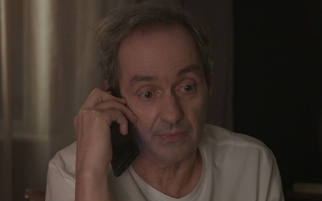 Daniel Dantas grava cena com expressão séria ao telefone, como Túlio, em Um Lugar ao Sol