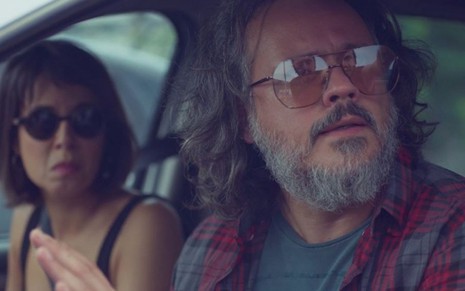 Mateus (Danton Mello) está assustado sentado ao lado de Lara (Andréia Horta) dentro de carro em Um Lugar ao Sol