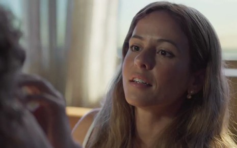 Érica (Fernanda de Freitas) em cena de Um Lugar ao Sol; atriz olha atentamente para alguém na sua frente