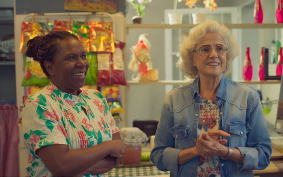 Ju Colombo e Marieta Severo gravam cena com sorriso apreensivo, como Dalva e Noca, na novela Um Lugar ao Sol