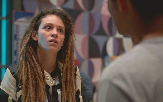 Joy (Lara Tremouroux) está em rodoviária em cena de Um Lugar ao Sol