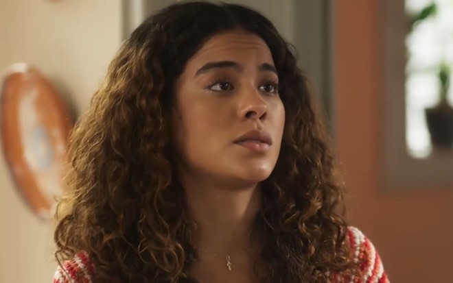 Bella Campos com expressão séria em cena como Jenifer na novela Vai na Fé