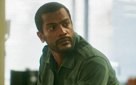 O ator Samuel de Assis está em cena da novela Vai na Fé com uma camisa verde caracterizado como Ben