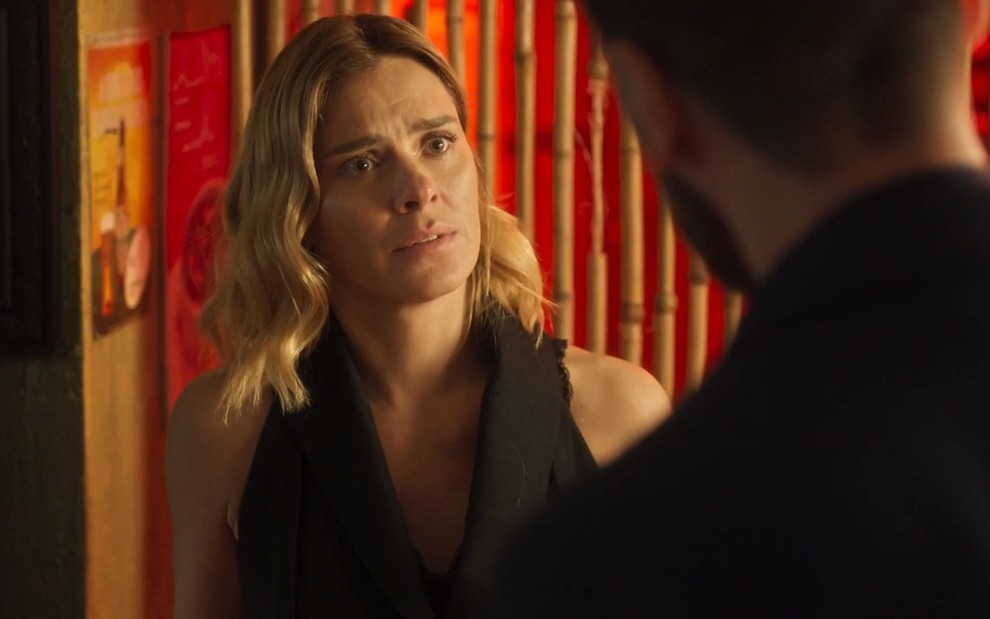 Lumiar (Carolina Dieckmann) com expressão de tristeza diante de Theo (Emilio Dantas) em cena da novela Vai na Fé