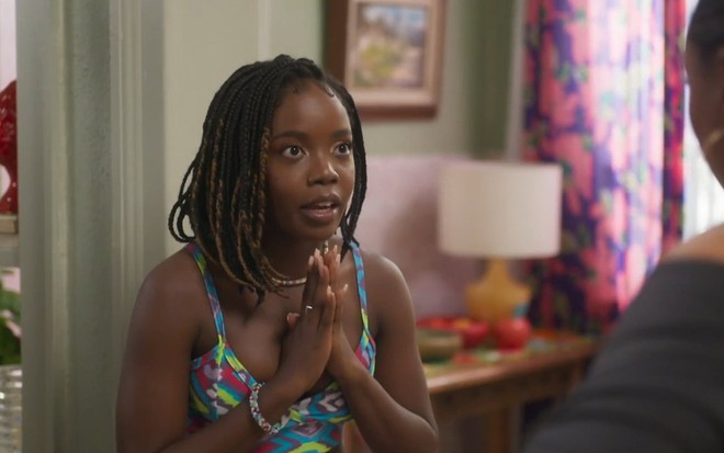 Clara Moneke tem as mãos juntas, como se estivesse em oração, em cena de Vai na Fé
