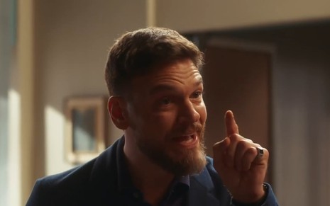 Theo (Emilio Dantas) com o dedo em riste em cena de Vai na Fé