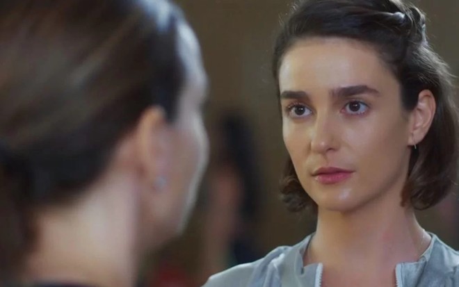 Regiane Alves, de costa e cortada na imagem, contracena com Priscila Sztejnman em Vai na Fé