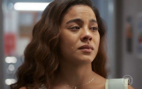 A atriz Bella Campos está com lágrima no rosto e expressão de tristeza em cena da novela Vai na Fé