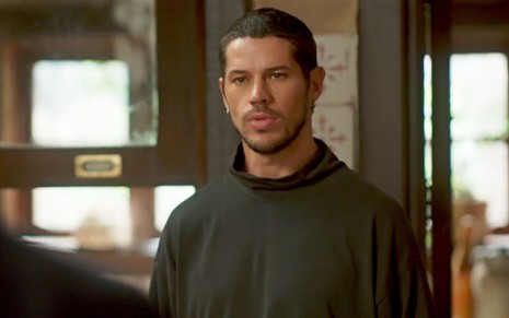 José Loreto caracterizado como Lui Lorenzo em Vai na Fé; ele usa um moletom preto e tem o semblante abatido em cena da novela