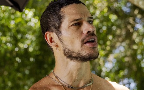 José Loreto caracterizado como Lui Lorenzo em Vai na Fé; ele está sem camisa e dá um sorriso sedutor em cena da novela