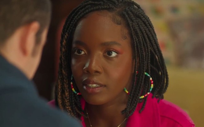 Clara Moneke caracterizada como Kate em Vai na Fé; ela usa tranças e tem o semblante abatido