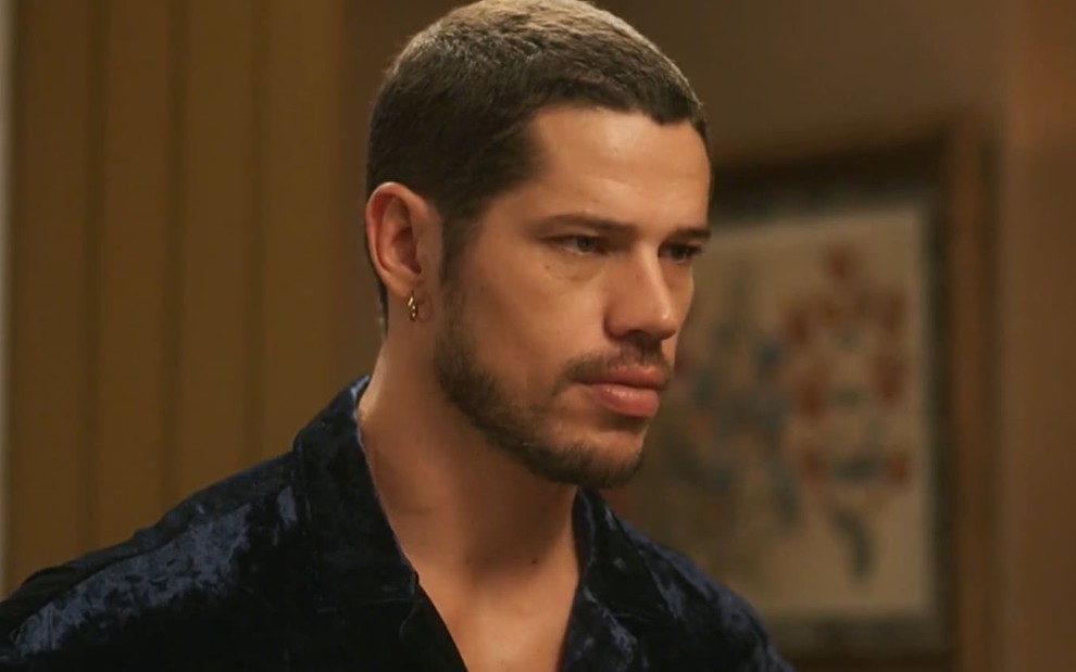 José Loreto caracterizado como Lui Lorenzo em Vai na Fé; ele usa uma camisa preta e tem o semblante abatido em cena da novela