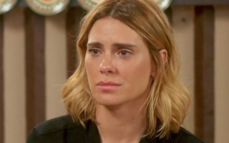 A atriz Carolina Dieckmann está com expressão de tristeza em cena da novela Vai na Fé como a personagem Lumiar