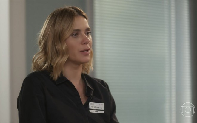 A atriz Carolina Dieckmann usa camisa preta e está de perfil em cena da novela Vai na Fé como Lumiar