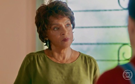 A atriz Elisa Lucinda faz uma expressão série em cena de Vai na Fé na qual usa uma blusa verde como Marlene