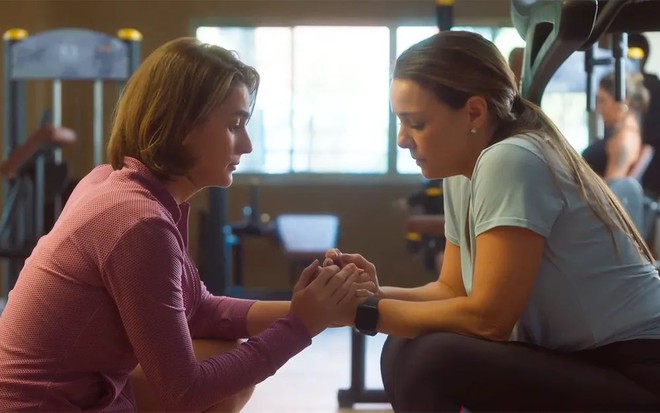 Priscila Sztejnman e Regiane Alves seguram suas mãos em cena de Vai na Fé