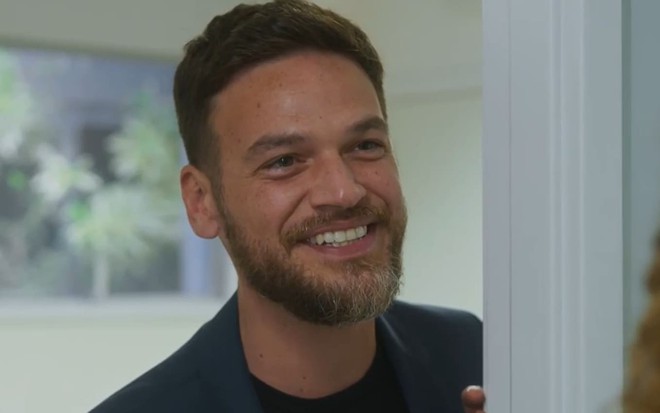 Emilio Dantas caracterizado como Theo em Vai na Fé; ele dá um sorriso debochado em cena da novela
