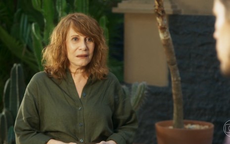 A atriz Renata Sorrah está séria e usa uma camisa verde em cena da novela Vai na Fé como a personagem Wilma
