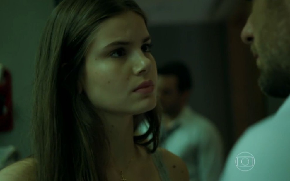 Camila Queiroz grava cena com expressão tensa para Rodrigo Lombardi, que aparece de costas para a imagem, como Angel e Alex