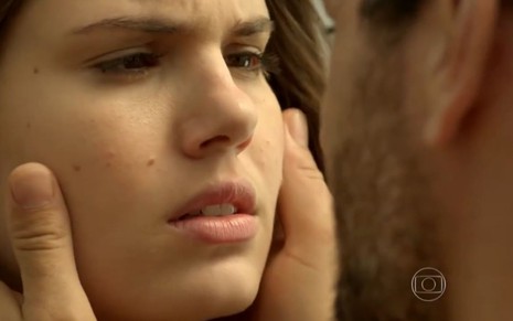 Camila Queiroz grava cena com expressão tensa para Rodrigo Lombardi, que aparece de costas para a imagem, como Angel e Alex