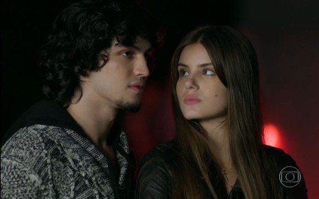 Gabriel Leone grava cena com expressão séria, sendo olhado por Camila Queiroz, como Gui e Angel em Verdades Secretas