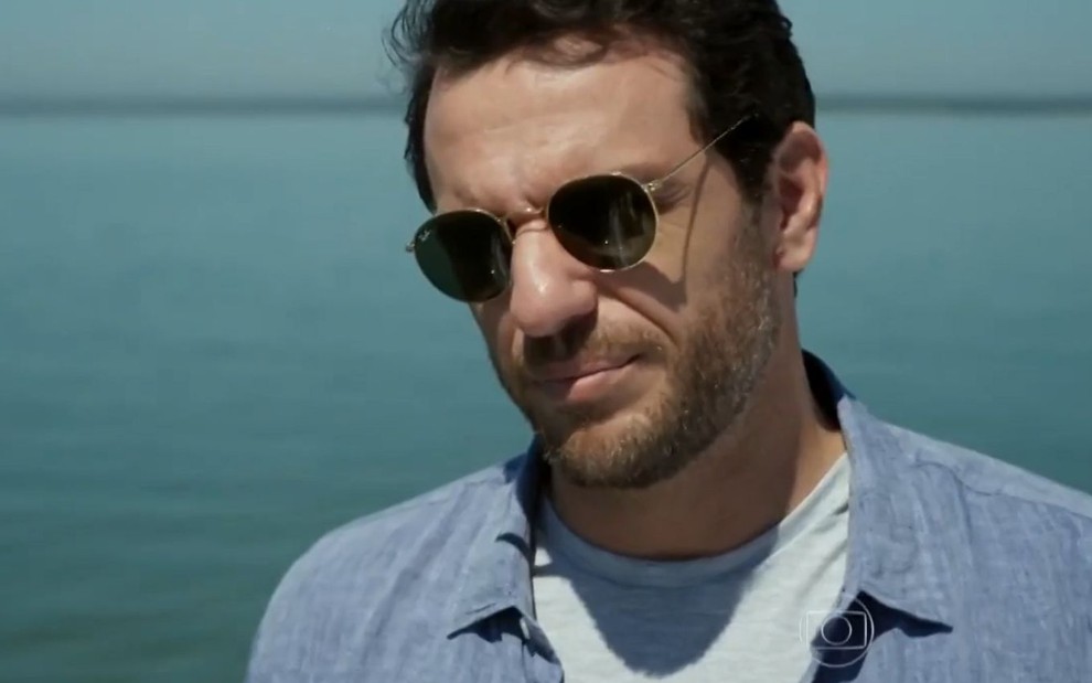 Rodrigo Lombardi grava cena com expressão séria, de óculos escuros, como Alex em Verdades Secretas, da Globo