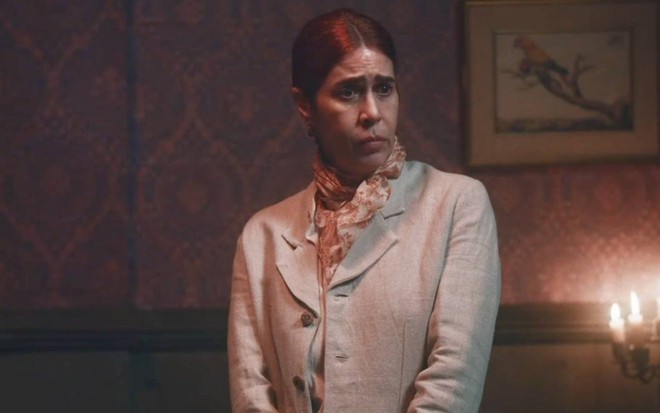Atriz Maria Clara Gueiros olha para baixo com cara de indignação em Nos Tempos do Imperador