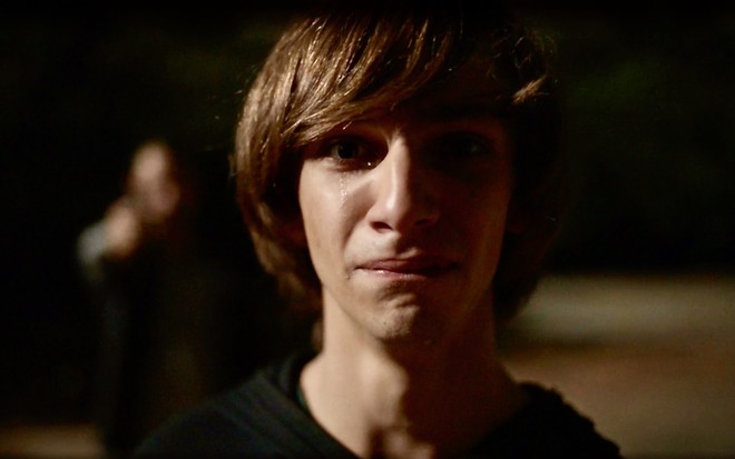 Antonio Haddad está com uma lágrima escorrendo em cena noturna da série Os Outros como o personagem Marcinho