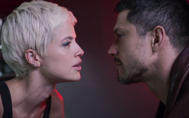 Agatha Moreira e Romulo Estrela gravam cena ambos com expressão séria para o outro, como Giovanna e Cristiano