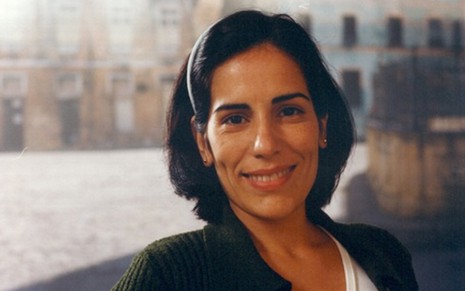 Glória Pires com um casaco preto e blusa branca em uma foto de divulgação da novela Anjo Mau, de 1997