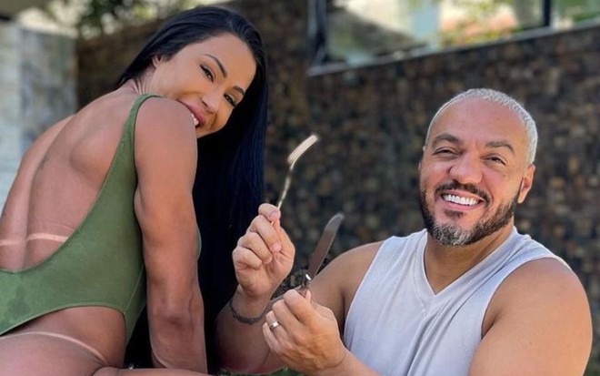 Imagem de Gracyanne Barbosa (de costas, à esq.) e Belo segurando garfo e faca