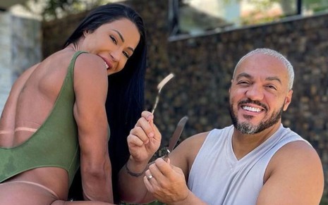 Imagem de Gracyanne Barbosa (de costas, à esq.) e Belo segurando garfo e faca