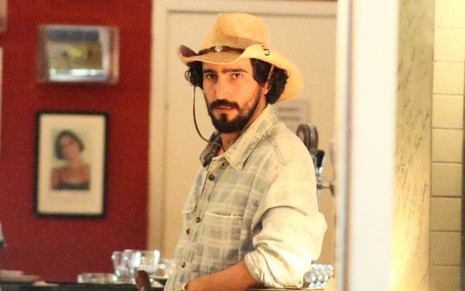 Renato Góes usa chapéu de palha e está caracterizado como o personagem José Leôncio nas gravações de Pantanal