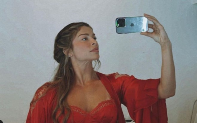 A atriz Grazi Massafera tira foto com figurino de época no espelho