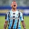 Janderson, do Grêmio, grita ao comemorar gol e veste uniforme listrado em branco, preto e azul