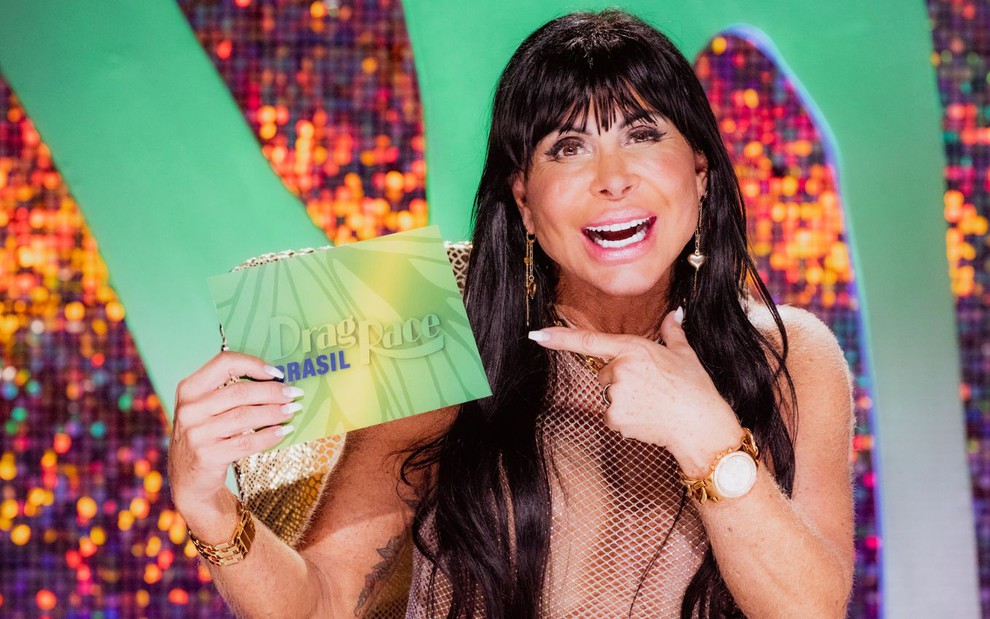 Gretchen segura uma ficha com o logo de Drag Race Brasil