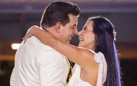 Vestidos de branco, Gretchen e o marido, Esdras de Souza, se abraçam e encostam os narizes