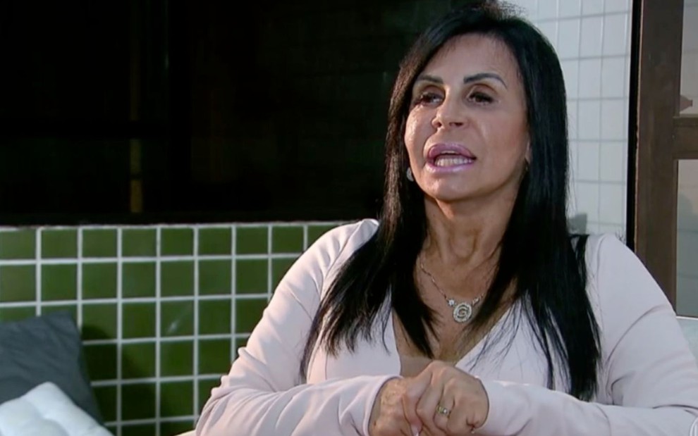 Gretchen em entrevista à Globo, com expressão séria, blusa branca